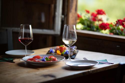 two glasses of wine and a plate of food on a table at Arzenhof, Baron Di Pauli in Caldaro