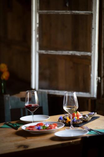 a table with two glasses of wine and food on it at Arzenhof, Baron Di Pauli in Caldaro