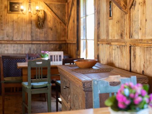 a dining room with a table and chairs and a wooden wall at Arzenhof, Baron Di Pauli in Caldaro