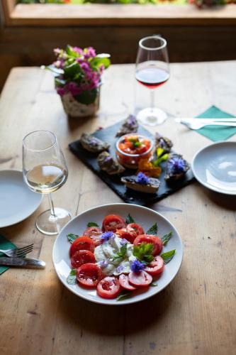 a table with a plate of food and glasses of wine at Arzenhof, Baron Di Pauli in Caldaro
