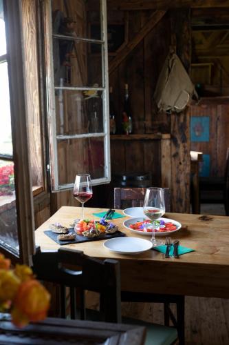 a wooden table with two glasses of wine on it at Arzenhof, Baron Di Pauli in Caldaro