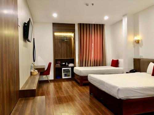 a hotel room with two beds and a television at Le Centre Pleiku Hotel in Pleiku