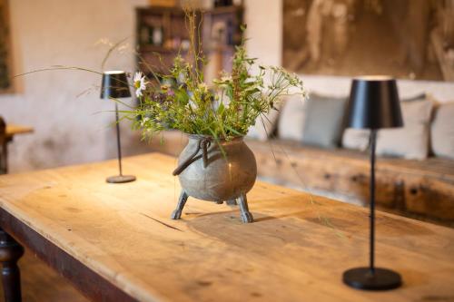 a table with a vase with flowers on it at Arzenhof, Baron Di Pauli in Caldaro