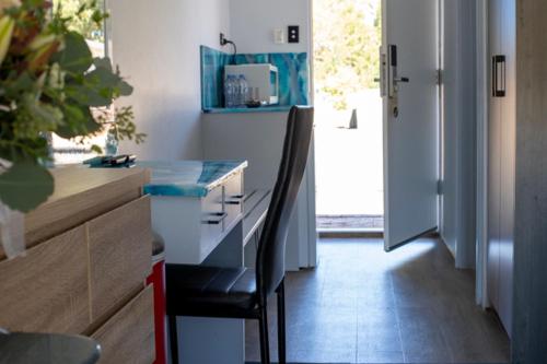 a kitchen with a black chair sitting at a counter at Manjimup Motor Inn in Manjimup