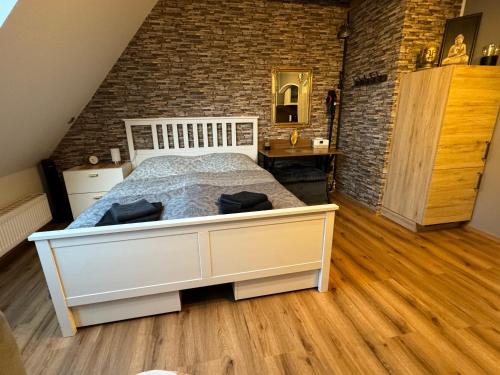 sypialnia z białym łóżkiem i ceglaną ścianą w obiekcie Nieman‘s Loft w mieście Emden