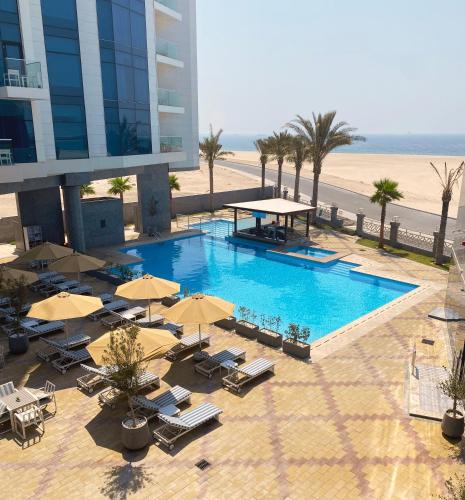 an overhead view of a swimming pool with chairs and umbrellas at Sea Point Hotel Dubai Islands Formerly Park Regis by Prince in Dubai