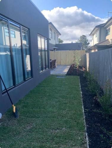 a yard with a house and a fence at ‘The bayside’ Beautifully brand new house in Mentone
