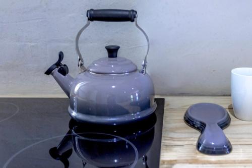 a blue tea pot sitting on a table with a cup at Sandton Cozy Apartment in Johannesburg