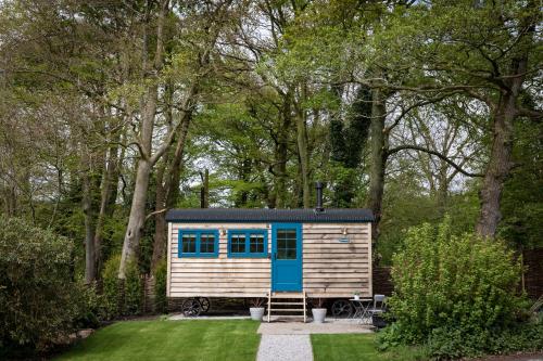 a tiny house in the middle of a yard at Woodlands Shepherds Hut Chatsworth Estate in Baslow