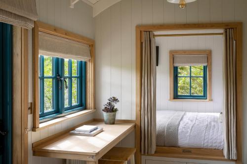 a bedroom with a bed and a mirror at Woodlands Shepherds HutChatsworth Estate in Baslow