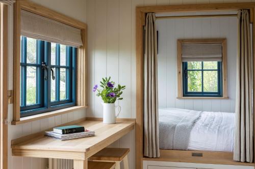 a bedroom with a bed and a table with a mirror at Stag Shepherds HutChatsworth Estate in Baslow