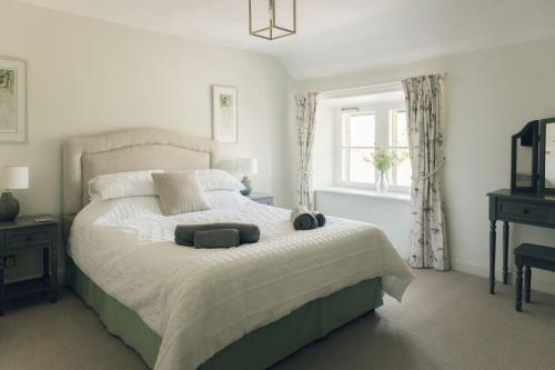 a bedroom with a large bed and a window at Keepers CottageChatsworth Estate in Baslow