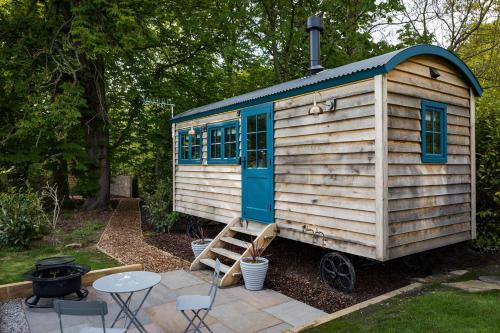 a tiny house with a ladder in a yard at Oak Tree Shepherds Hut Chatsworth Estate in Baslow