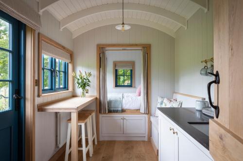 a kitchen with a counter and a sink and a window at Oak Tree Shepherds Hut Chatsworth Estate in Baslow