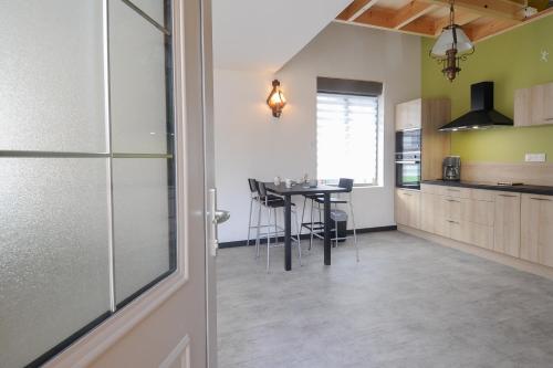 une cuisine avec une table et une salle à manger dans l'établissement GITE neuf LUXE - Sauna Privé Extérieur, à Gosnay