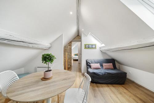 une salle à manger avec une table et un canapé dans l'établissement La Maison Jaff, à Beaune