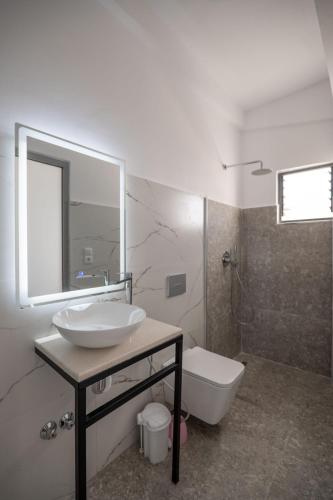 a bathroom with a sink and a toilet and a mirror at Sunset Aparthotel in Sarandë
