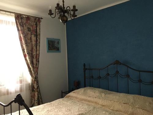 1 dormitorio con cama y pared azul en Öregporta Vendégház en Bazsi