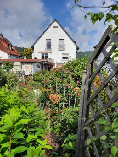 a garden in front of a white house at Ferienwohnung Gaby in Marburg an der Lahn
