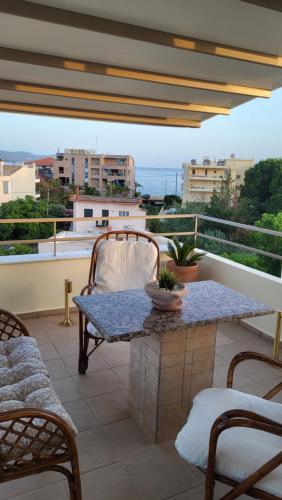 a patio with a table and chairs on a balcony at Vivere Terrace Seaside Kalamata in Faraí