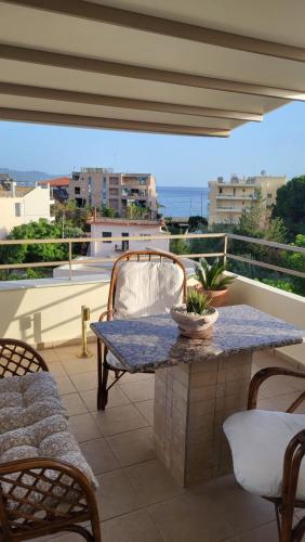 a table on a balcony with a view of the ocean at Vivere Terrace Seaside Kalamata in Faraí