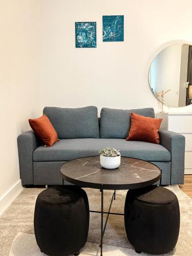 un salon avec un canapé bleu et une table dans l'établissement Le cosy et confortable à 15min à pied de la gare, à Valence