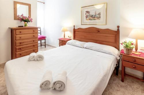 une chambre avec un grand lit blanc avec des serviettes dessus dans l'établissement Fener de Dalt 88 - apartamento con wifi y piscina, à Llançà