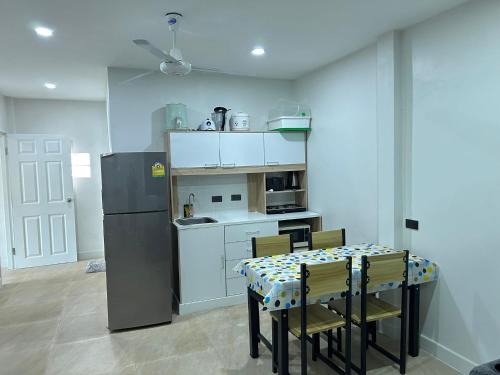 a kitchen with a table with chairs and a refrigerator at Aussieland Bungalows in Lamai
