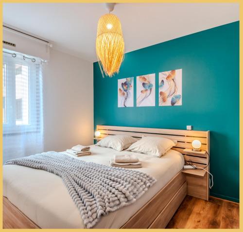 une chambre avec un grand lit avec un mur bleu dans l'établissement Chez Chris I T2 I Annemasse, à Annemasse