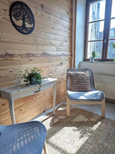 a table and two chairs in a room with a wall at Vivez dans un magnifique village Normand in La Carneille