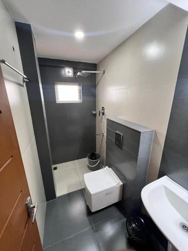un baño con inodoro y lavabo en BLIZZ REGENCY, en Ernakulam