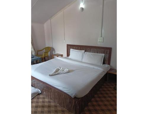 a bed with white sheets and white towels on it at Hotel Royal sultan Resort, Pahalgam in Pahalgām