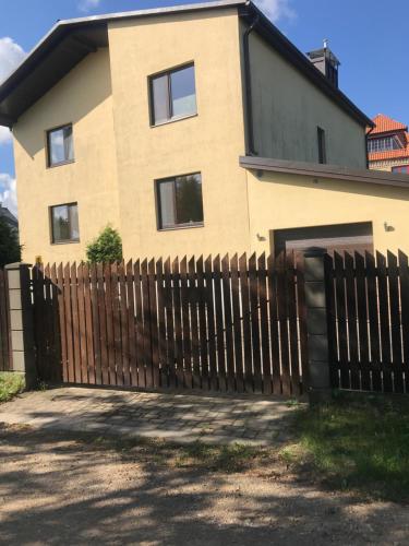 a house with a wooden fence in front of it at House on the sea side in Ragaciems
