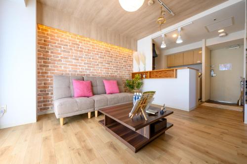 a living room with a couch and a brick wall at Nakajima Park Hotel AMS tower Nakajima 20F 2001 in Sapporo