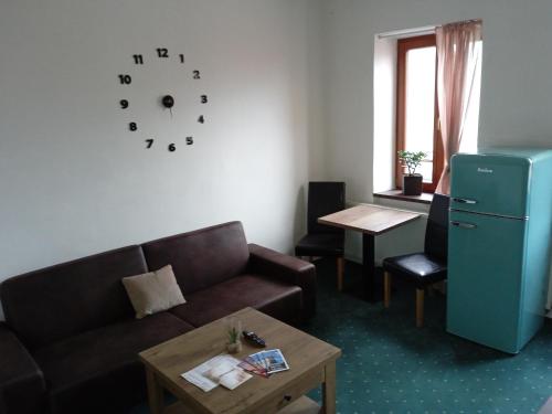 a living room with a couch and a table and a clock at Demaris in Třebíč