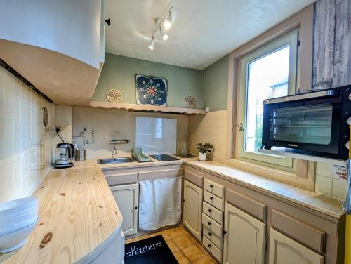 a kitchen with a counter and a sink and a window at Vivez dans un magnifique village Normand in La Carneille