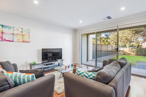 a living room with two couches and a tv at Coastal Parkside - Glenelg North - C21 SouthCoast Holidays in Glenelg