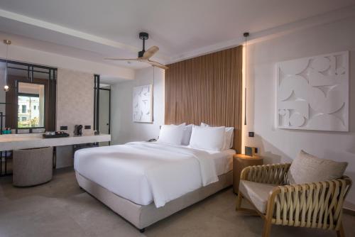 a bedroom with a large white bed and a chair at Noble Hotel & Suites - Adults Only in Gouves