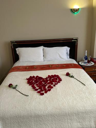a pile of red roses laying on a bed at Hostal CASA FRANCISCANA in Quito