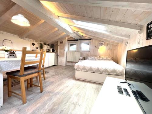 una camera con letto e tavolo e una cucina di Il piccolo Loft nel cuore antico di Aosta - You & Me case vacanza ad Aosta
