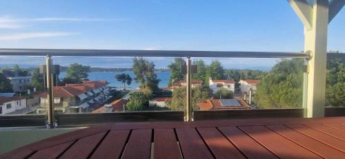 a balcony with a view of a town and water at Makis Nest Apart-Hotel in Vourvourou