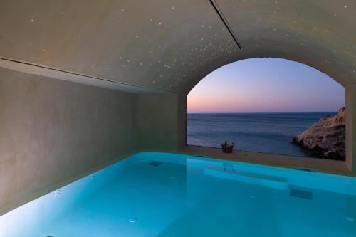 a bath tub with a view of the ocean at Stone Luxury Suites - Adults Only in Archangelos