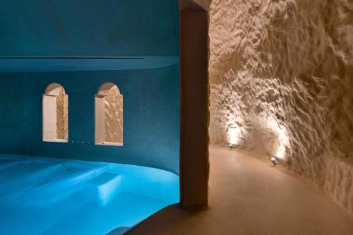a blue room with a bed and a tunnel at Stone Luxury Suites - Adults Only in Archangelos