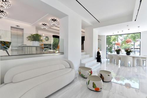 a white living room with a white couch and chairs at The Athenaeum Luxury Hotel in Athens
