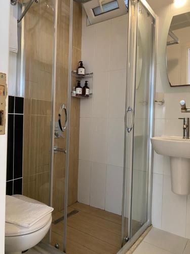 a bathroom with a shower and a toilet and a sink at Amsterdam Otel & Suite Apart in Kemer