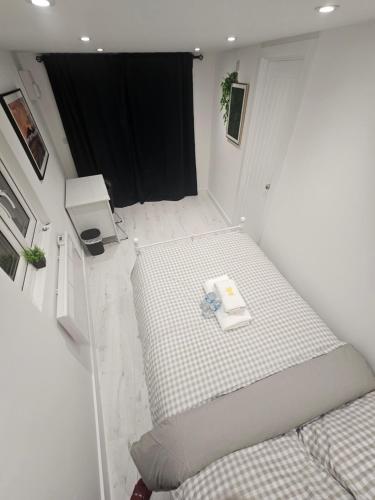 a small bedroom with a bed and a black curtain at Modern Double Room in Dartford- Private Entrance in Kent