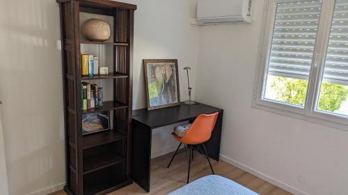 a desk with a chair next to a book shelf at 2 Pieces - Cosy - Parking Securisé in Gradignan