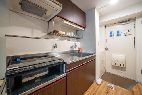 a kitchen with a sink and a stove top oven at Hotel Flourish 67 in Sapporo