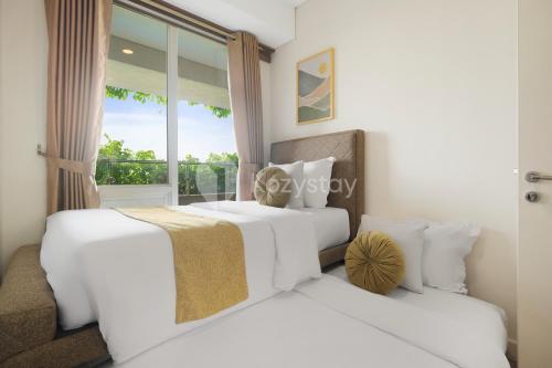 two white beds in a room with a window at Bhumi by Kozystay - Paskal in Bandung