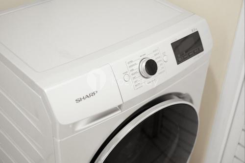 a white washing machine with its door open at Bhumi by Kozystay - Paskal in Bandung